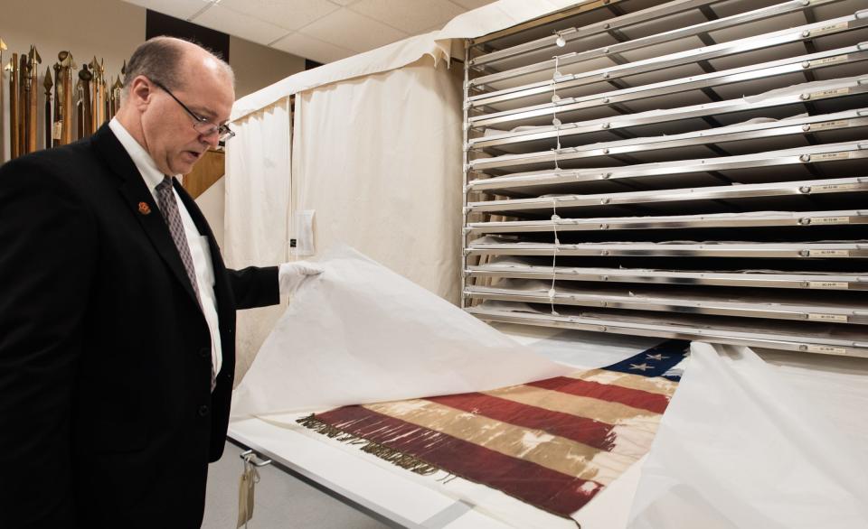 Matt Van Acker, director for the Michigan Capitol Tour Service and curator of Save The Flags reveals blood stains seen in this Michigan Civil War regiment battle flag Friday, Sept. 29, 2023. It is one of the 240 Michigan regiment battle flags housed at the Michigan History Museum in Lansing. The flags are stored in highly controlled environment to mitigate any further degradation from light, humidity, and temperature changes.
