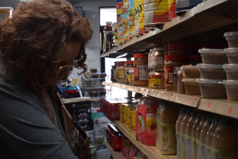 Interfaith Chaplain Jen Dreiske sifts through products at Mogadishu Grocery Store during an Augustana University Halal market shopping trip Saturday, March 9, 2024, in Sioux Falls, South Dakota.