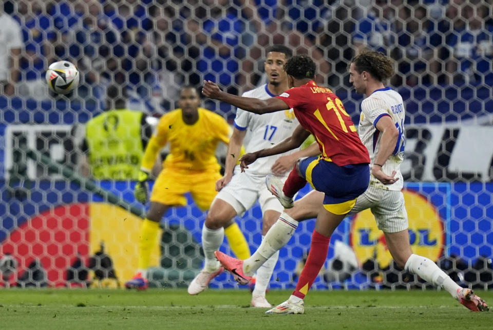 Spain's Lamine Yamal, center, scores his side's first goal during a semifinal match between Spain and France at the Euro 2024 soccer tournament in Munich, Germany, Tuesday, July 9, 2024. (AP Photo/Matthias Schrader)