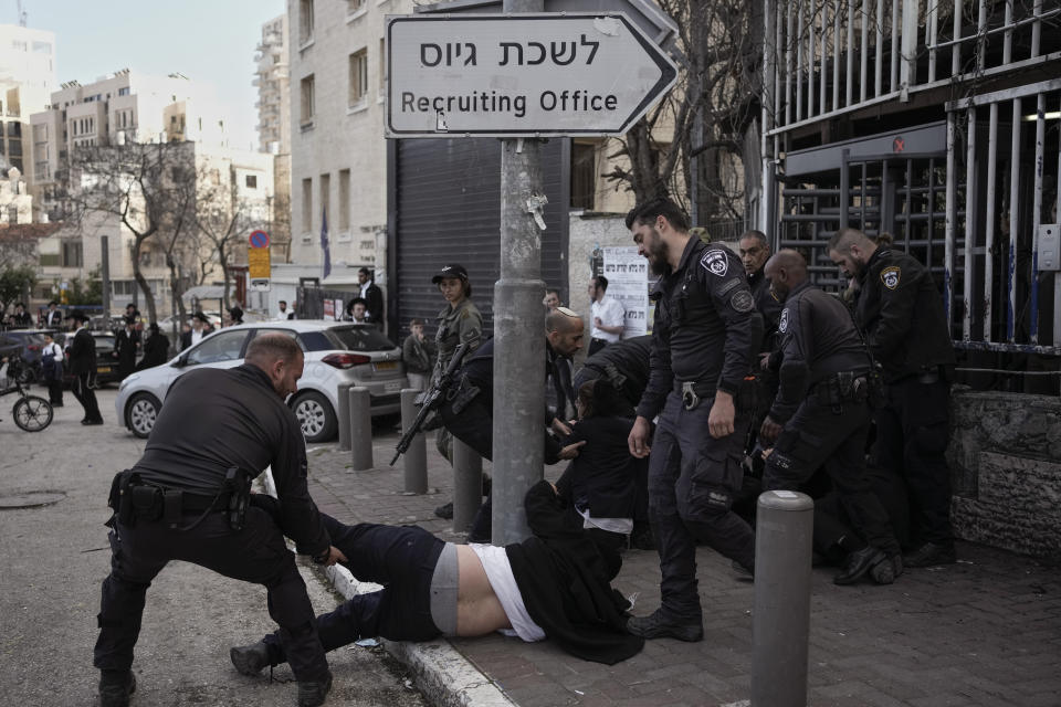 FILE - Israeli police officers scuffle with ultra-Orthodox Jewish men during a protest against possible changes to the military draft laws, outside a military recruitment office in Jerusalem, on March 4, 2024. Israel's High Court ruling Thursday to curtail subsidies for ultra-Orthodox men has thrown Prime Minister Benjamin Netanyahu's political future into grave jeopardy. Netanyahu now has until Monday to present the court with a plan to dismantle what the justices called a system that privileges the ultra-Orthodox at the expense of the country's majority. (AP Photo/Leo Correa, File)