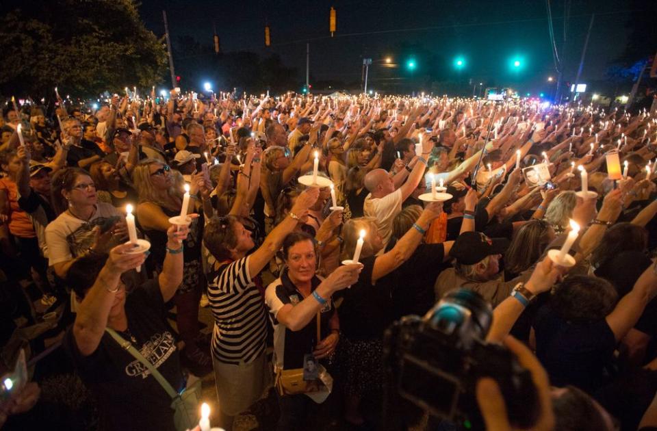 Fans hold candles during a vigil for Elvis Presley at Graceland | AP Photo/Brandon Dill