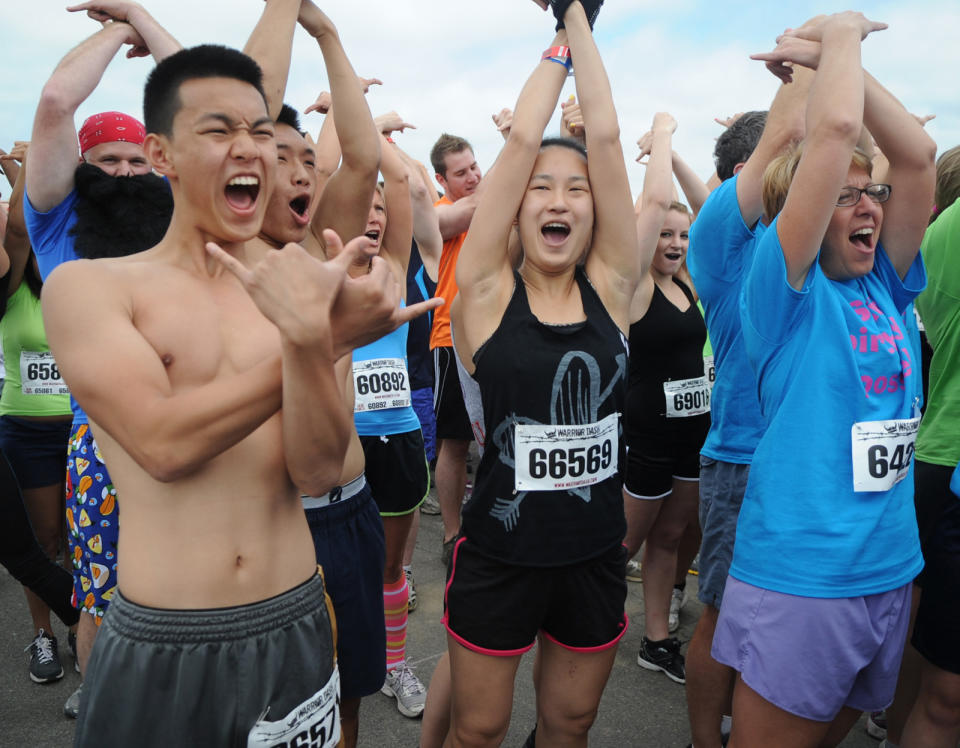 In this June 17, 2012 photo, Koncheng Moua, left, and Christine Moua of Lancaster first time racers, get pumped up to start the Warrior Dash at Pocono Raceway in Long Pond, Pa. Virtually overnight, obstacle courses have become a favorite diversion of thrill-seekers and weekend warriors. (AP Photo/Scranton Times & Tribune, Melissa Evanko) WILKES BARRE TIMES-LEADER OUT; MANDATORY CREDIT