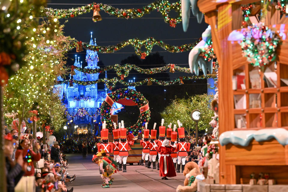 Christmas at Disney World with toy soldiers marching towards the lit up castle, under garland and wreaths.