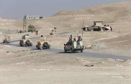 Federal police forces drive military vehicles during an operation against Islamic State militants in Qayyara, south of Mosul October 26, 2016. REUTERS/Alaa Al-Marjani