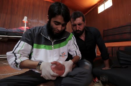 A displaced Syrian refugee attends a session at a physiotherapy clinic inside a large tent in the border village of Shamarin