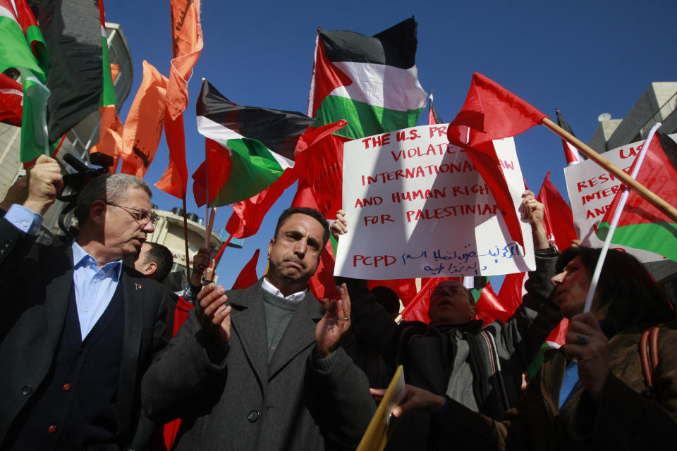 Palestinian protesters waving national and Popular Front for the Liberation of Palestine flags chant slogans during a demonstration against U.S. Secretary of State John Kerry in the West Bank city of Ramallah, Wednesday, Jan. 15, 2014. (AP Photo/Majdi Mohammed)