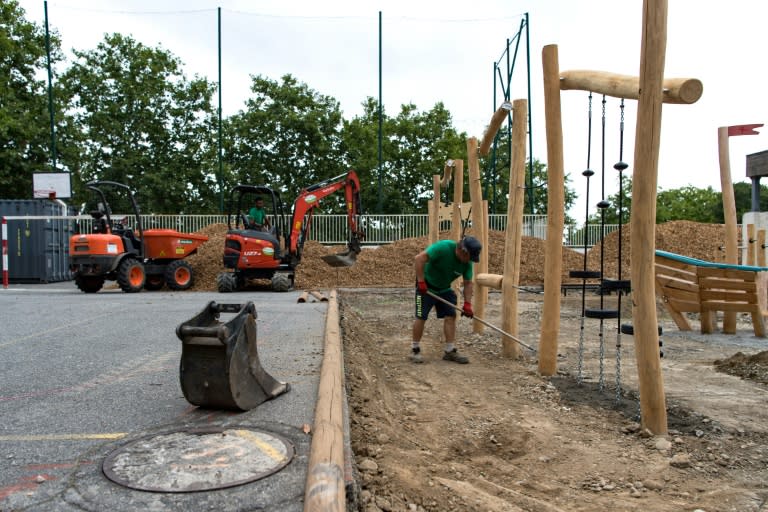 Un empleado trabaja en el acondicionamiento de una zona de juegos infantiles en el patio de una escuela de Toulouse, el 23 de agosto de 2024 al suroeste de Francia (Matthieu Rondel)