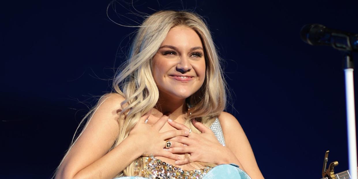 kelsea ballerini performing on stage with blue guitar