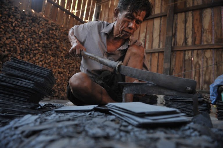 A man cuts tiles at a workshop in Baluu island near Mawlamyine, Myanmar's Mon state, on March 15, 2013. Locals say around 70 percent of households are missing the generation in between