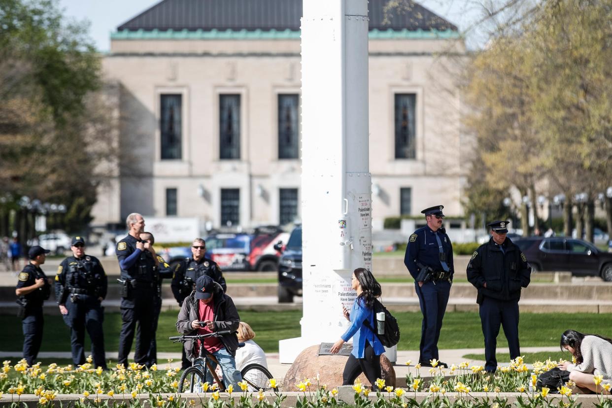 Michigan State Police troopers and University of Michigan Police officers watch the encampment for Gaza rally at U-M's Diag in Ann Arbor on Monday, April 22, 2024.