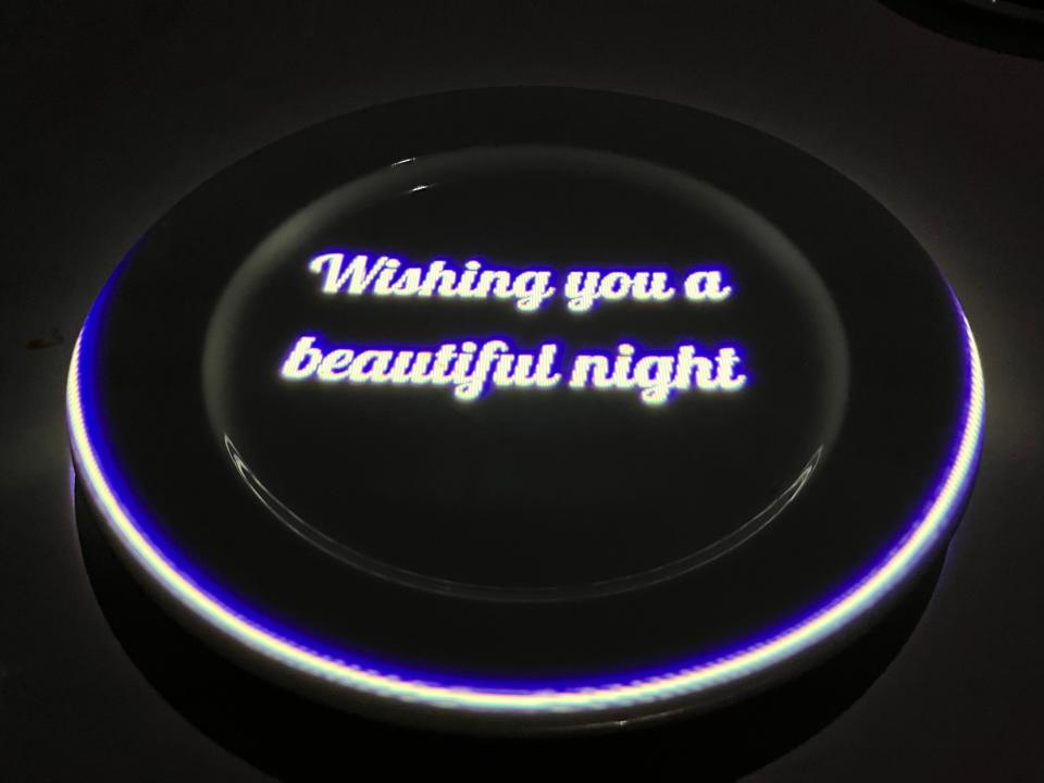 Dark plate and table at Le Petit Chef with "wishing you a beautiful night" projected onto it