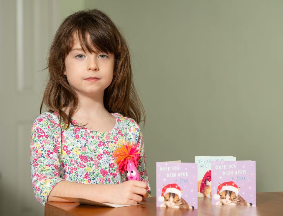 Florence Widdicombe, 6, at her home in Tooting, south London, writing in a Tesco Christmas card from the same pack as a card she found contained a message from a Chinese prisoner. The family who found a message from a Chinese prisoner in a Christmas card said they thought it was a 