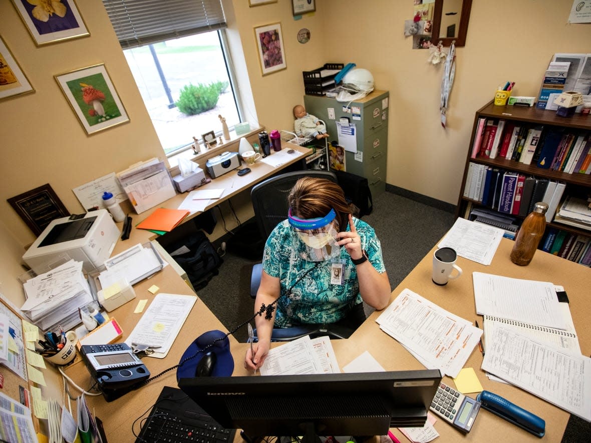 A public health nurse conducts a contact tracing phone call in Wyoming in this July file photo. Contact tracers in Alberta say they feel the province hasn't effectively been able to resume investigating COVID-19 cases after its plan to stop tracing this summer.  (Mike Moore/Gillette News Record/The Associated Press - image credit)