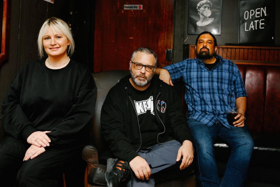 Three people sit for the camera.