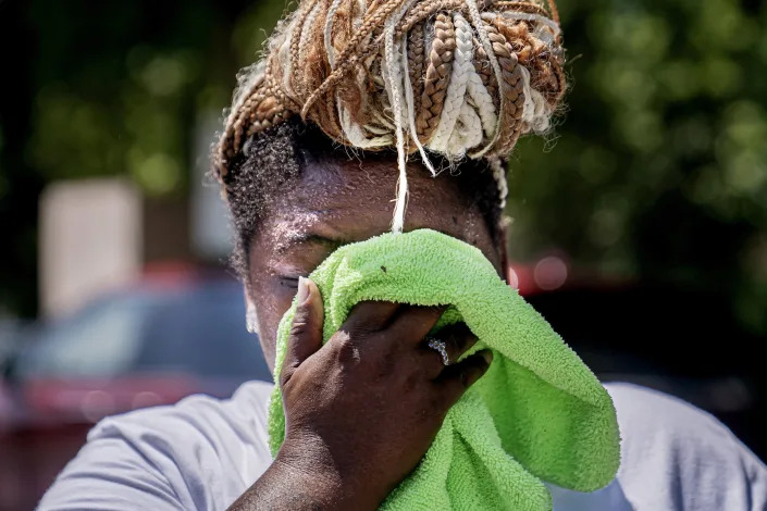 A woman wipes sweat from her face (Nathan Howard / AP)