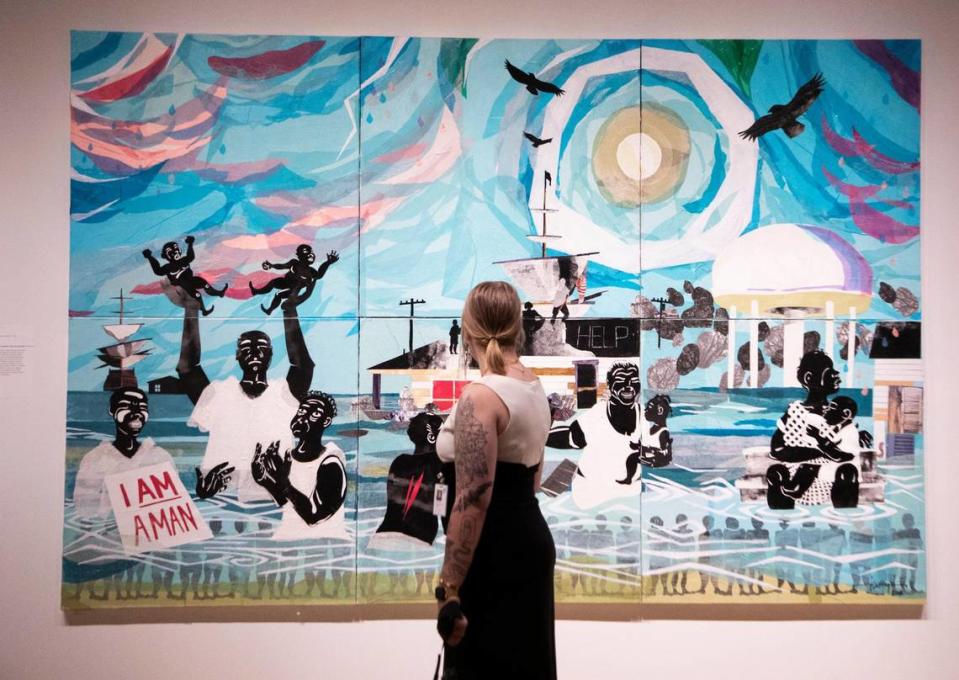 A viewer admires “Water” at Mint Museum Uptown’s new exhibit, “The Vault.” It explores collections of people who are on a mission to preserve Black art and culture in Charlotte.