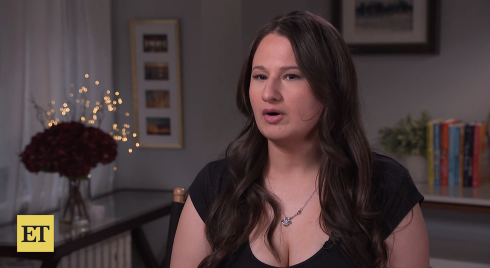 Gypsy in black top during an interview, with decorative background and "ET" logo visible