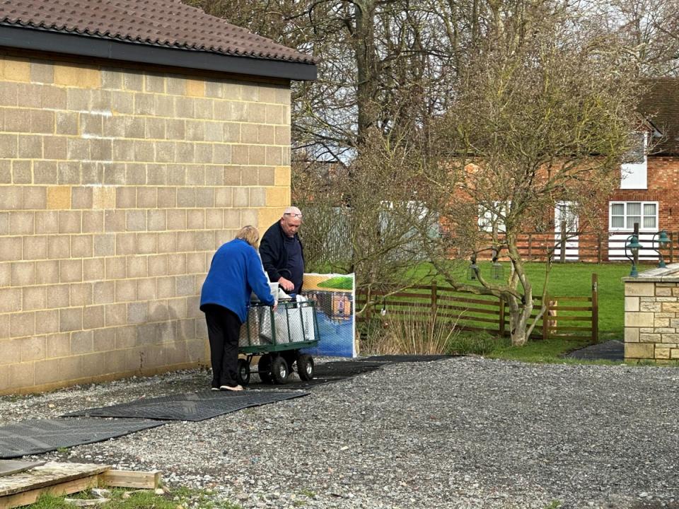 Items were taken away on a trolley from the building toward a van in the driveway at the house (The Independent)