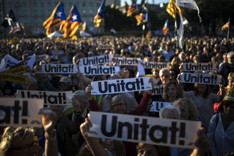 People hold independence flags and banners reading in Catalan "Unity" during a demonstration in downtown Barcelona, Spain, Wednesday, June 12, 2019. Catalan separatist leaders and activists told their Supreme Court trial on Wednesday they were exercising their democratic rights when they held a banned referendum on breaking away from Spain, denying charges of rebellion and sedition. (AP Photo/Emilio Morenatti)