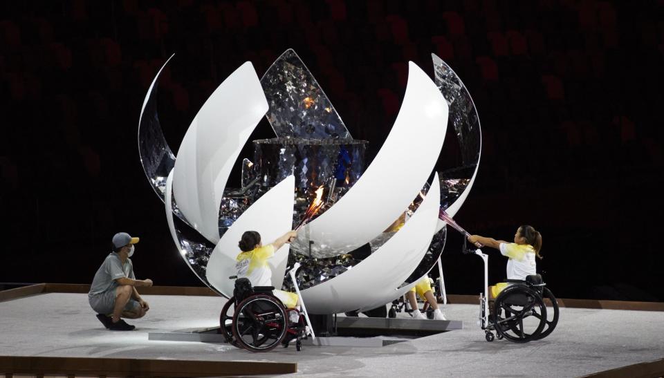 Three Japanese athletes light the flame as the Paralympics begin with an opening ceremony in Tokyo