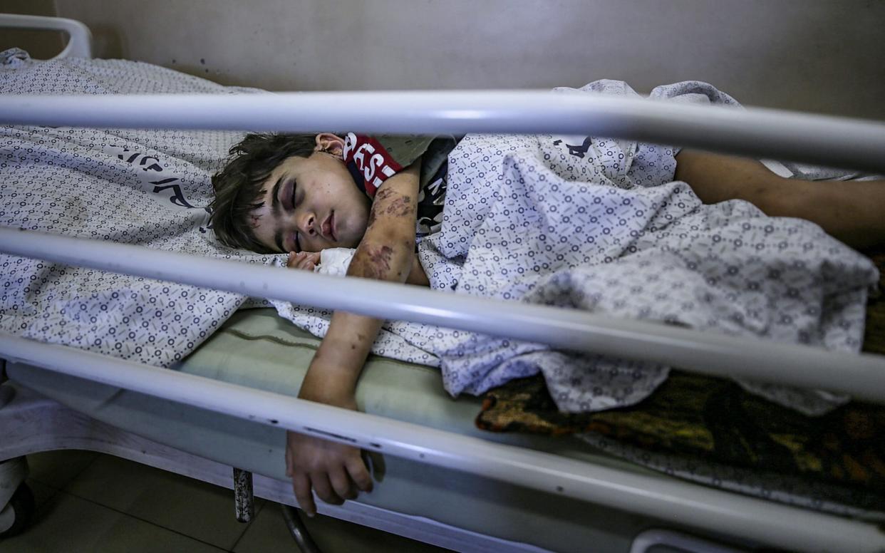 A Palestinian boy who was wounded in Israeli airstrikes lies in Al-Shifa hospital in Gaza City - HAITHAM IMAD/EPA-EFE/Shutterstock 