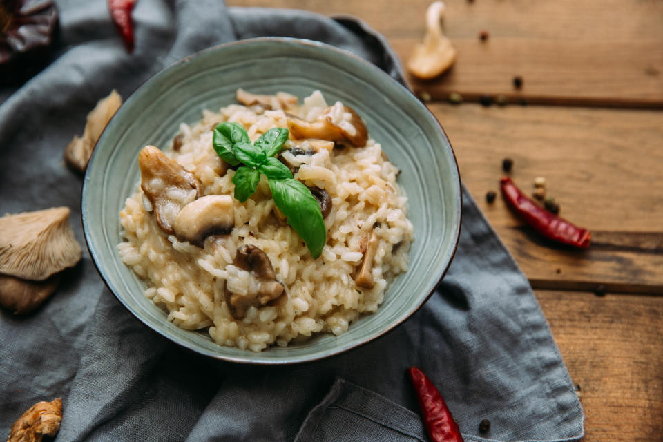 Risotto with mushrooms on an old wooden background. Rustic style.