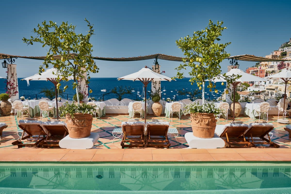 Guests can lounge poolside by the potted lemon trees while taking in the incredible views (Courtesy of Le Sirenuse Photographer/Credit Brechenmacher & Baumann)