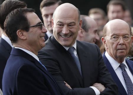 U.S. Treasury Secretary Steven Mnuchin stands with Chairman on the National Economic Advisory Gary Cohn and Commerce Secretary Wilbur Ross before President Donald Trump celebrated with Congressional Republicans after the U.S. Congress passed sweeping tax overhaul legislation, on the South Lawn of the White House in Washington, U.S., December 20, 2017. REUTERS/Carlos Barria