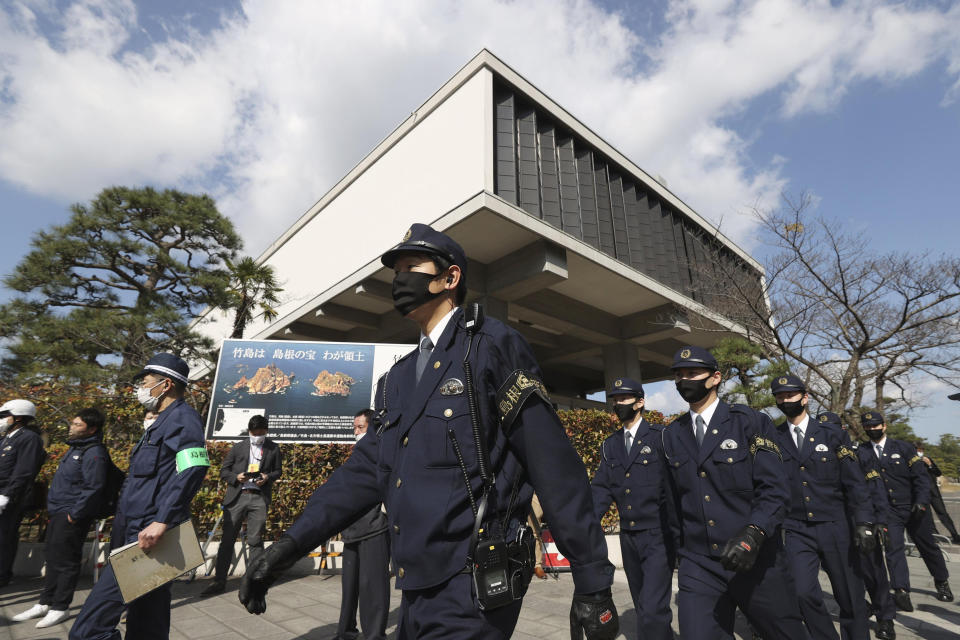 Police officers patrol near the venue of a ceremony to mark Shimane Prefecture-designated "Takeshima Day" in Matsue, Shimane prefecture, western Japan, Monday, Feb. 22, 2021. Japan renewed its claim on a contested island in the Sea of Japan held by South Korea at an annual event Monday, escalating tensions between the neighbors were already strained over Seoul's compensation claim over Tokyo's World War II atrocities. (Kyodo News via AP)