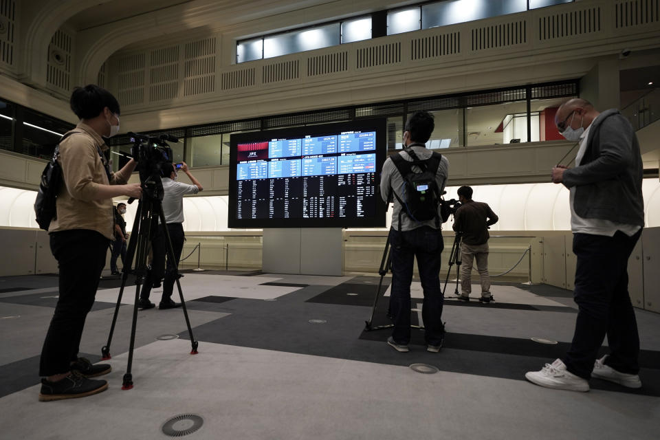 Members of media film the blank stock board at Tokyo Stock Exchange Thursday, Oct. 1, 2020, in Tokyo. The Tokyo Stock Exchange temporarily suspended all trading due to system problem. (AP Photo/Eugene Hoshiko)