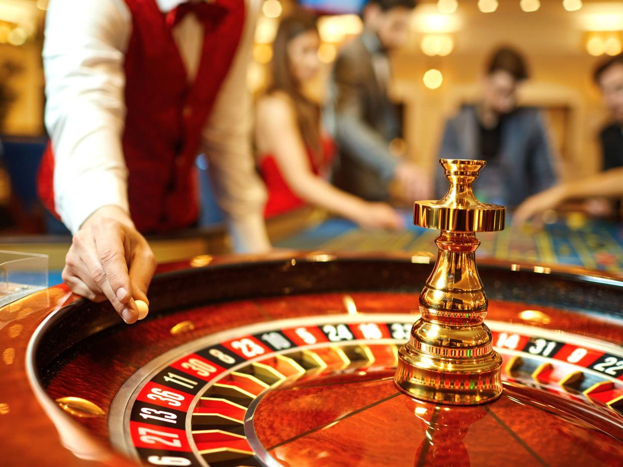 The croupier holds a roulette ball in a casino in his hand. Gambling in a casino.