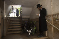 Ultra-Orthodox Jews keep social distancing and wear face masks during a morning prayer next to their houses as synagogues are limited to twenty people due to the coronavirus pandemic, in Bnei Brak, Israel, Thursday, Sept 24, 2020. For Israel's ultra-Orthodox Jews, coronavirus restrictions have raised numerous questions about how to maintain their religious lifestyle during the outbreak. A religious publisher in Jerusalem released a book in July with over 600 pages of guidance from 46 different rabbis. (AP Photo/Oded Balilty)