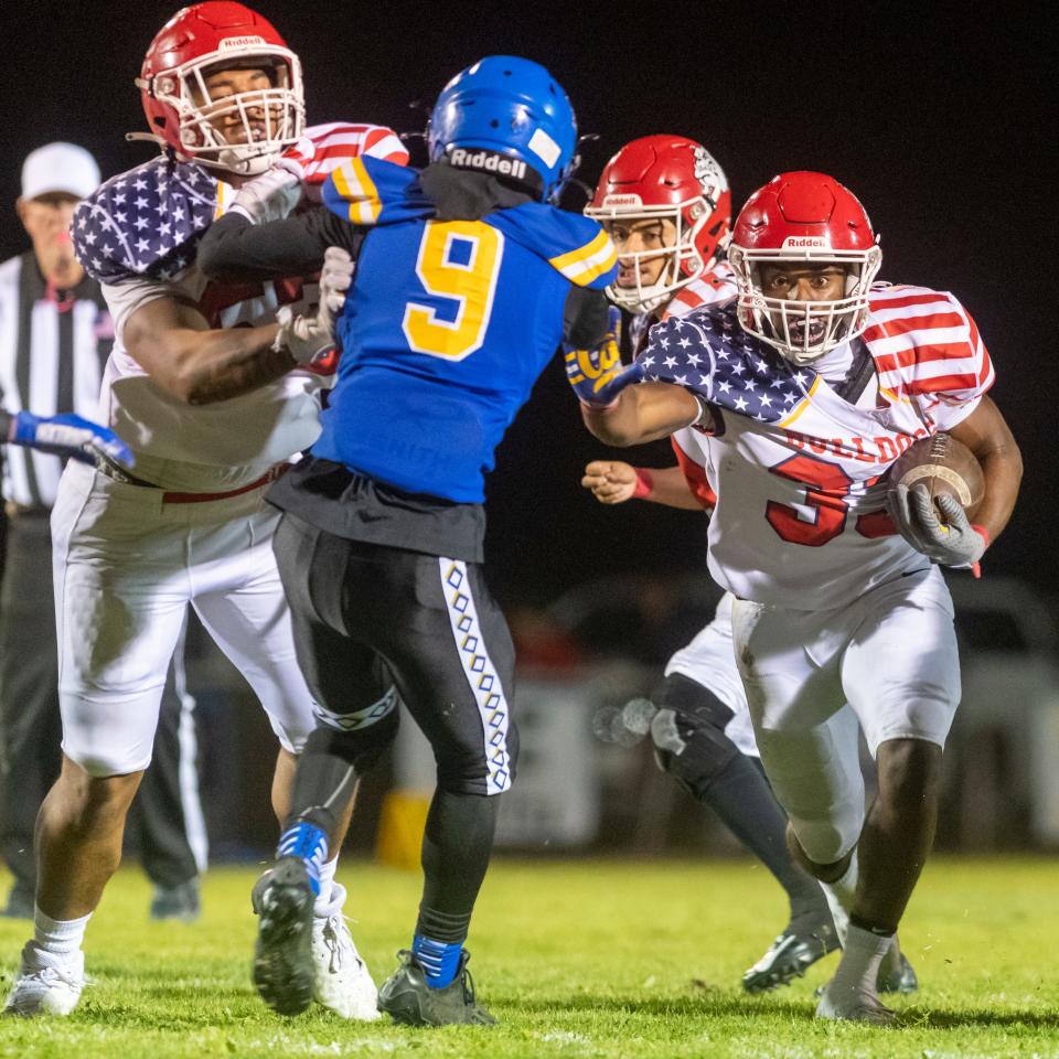 Oak Hills' Paki Finau, left, blocks a Serrano player while Karson Cox runs the ball on Friday, Oct. 06, 2023. Oak Hills beat Serrano 35-7 and improved to 2-0 in Mojave River League play.