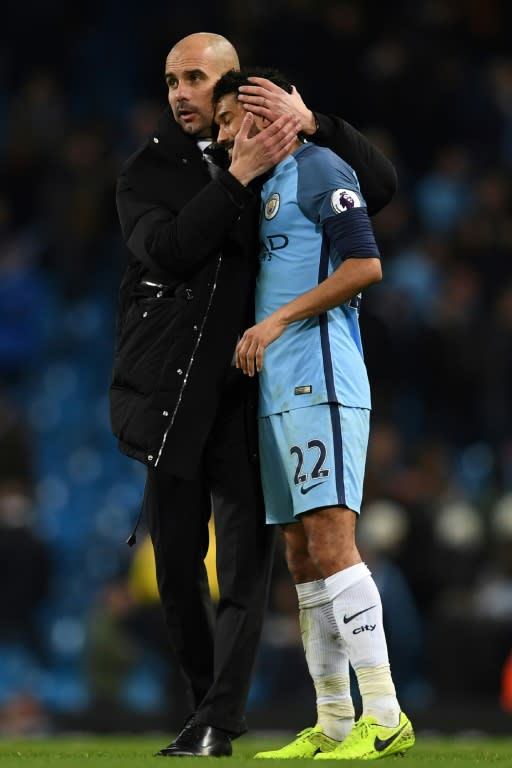 Manchester City's manager Pep Guardiola (L) embraces defender Gael Clichy in March 2017