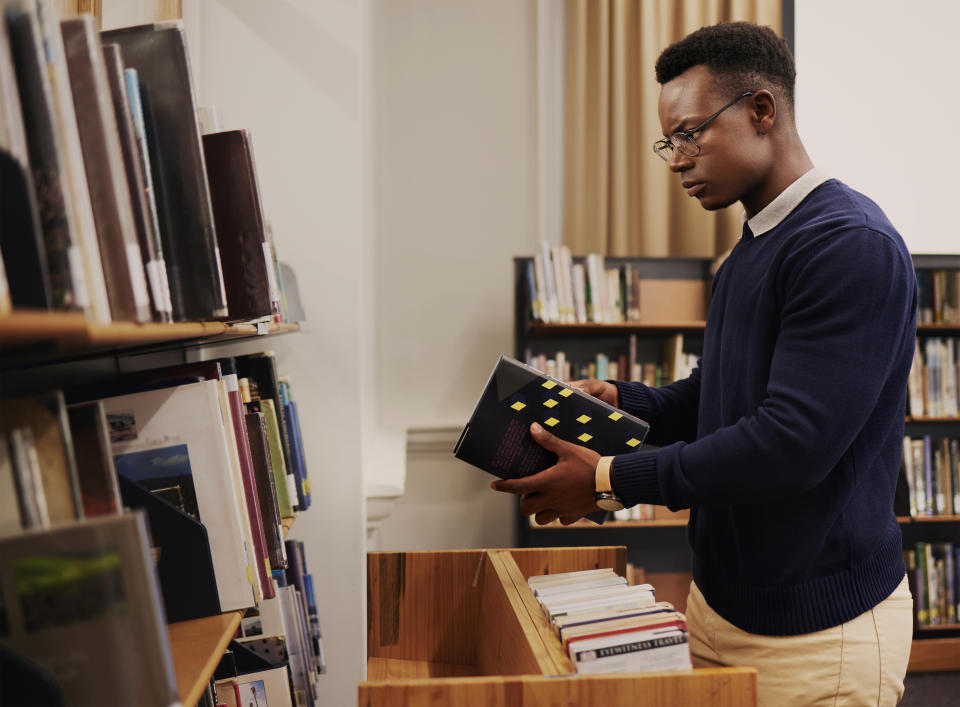 a male librarian shelving books