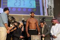 Officials check the weight of the British boxer Anthony Joshua during a weigh-in at Faisaliah Center, in Riyadh, Saudi Arabia, Friday, Dec. 6, 2019. The first ever heavyweight title fight in the Middle East, has been called the "Clash on the Dunes." Will take place at the Diriyah Arena on Saturday. (AP Photo/Hassan Ammar)