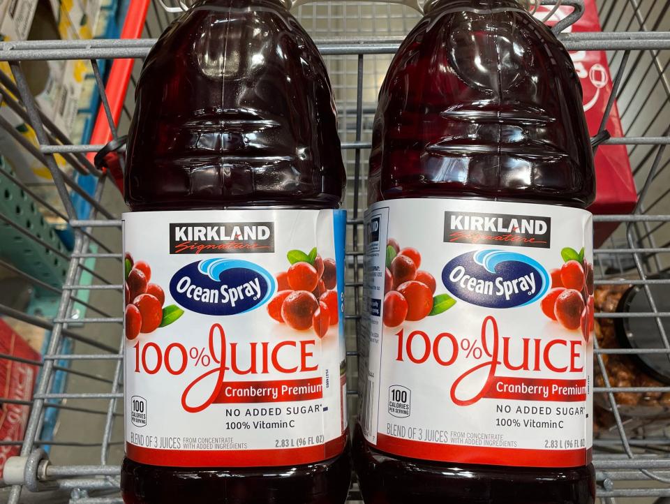 two bottles of cranberry juice in a cart at costco