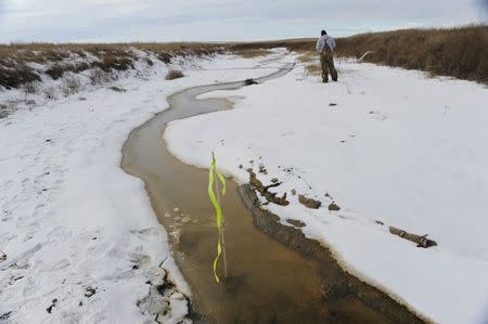 A maintenance worker continues clean-up efforts about 15 miles outside Williston, North Dakota January 22, 2015. REUTERS/Andrew Cullen