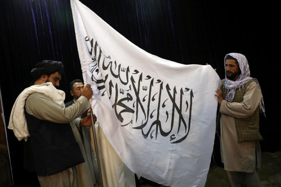 Taliban officials arrange a Taliban flag (Rahmat Gul/AP) (AP)