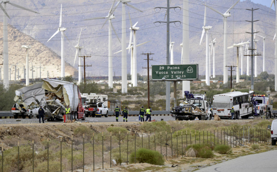 FILE - In this Oct. 23, 2016, file photo, tow truck drivers prepare to haul away a tour bus that crashed with a semi-truck on Interstate 10, west of the Indian Canyon Drive off-ramp, in Desert Hot Springs, near Palm Springs, Calif. Officials say Bruce Guilford, a trucker who fell asleep behind the wheel was sentenced, Friday, Aug. 30, 2019, to four years in state prison after he pleaded guilty to causing a tour bus crash on a Southern California freeway that killed 13 people in 2016. (AP Photo/Rodrigo Pena, File)