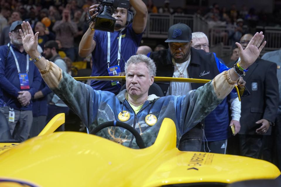 Actor Will Ferrell waves to the fans as he sits in a race car pushed by Rapper 50 Cent before an NBA basketball game between the Philadelphia 76ers and the Indiana Pacers, Monday, March 6, 2023, in Indianapolis. (AP Photo/Darron Cummings)