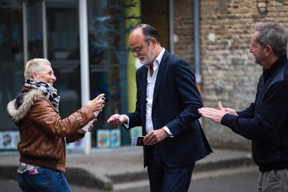 Former French Prime Minister Edouard Philippe (C) disinfects his hands as he queues to vote (AFP via Getty Images)