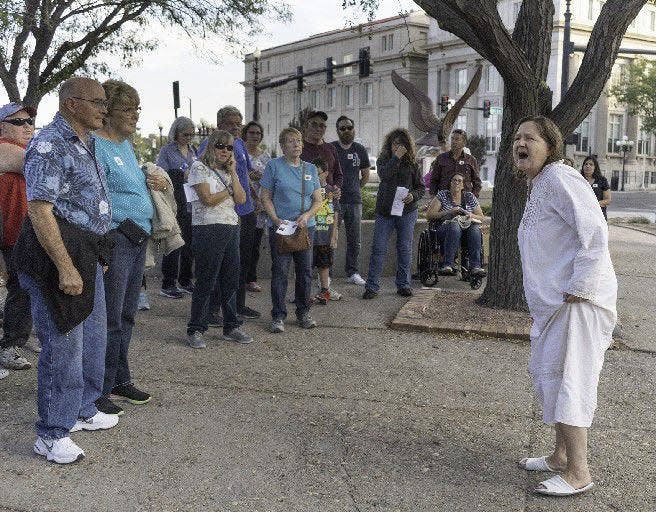 A crowd gathers around Judith Cook as she portrays Bridgette, an inmate who died at the Colorado Insane Asylum, during the Historical Pueblo Ghost Walk in 2018.