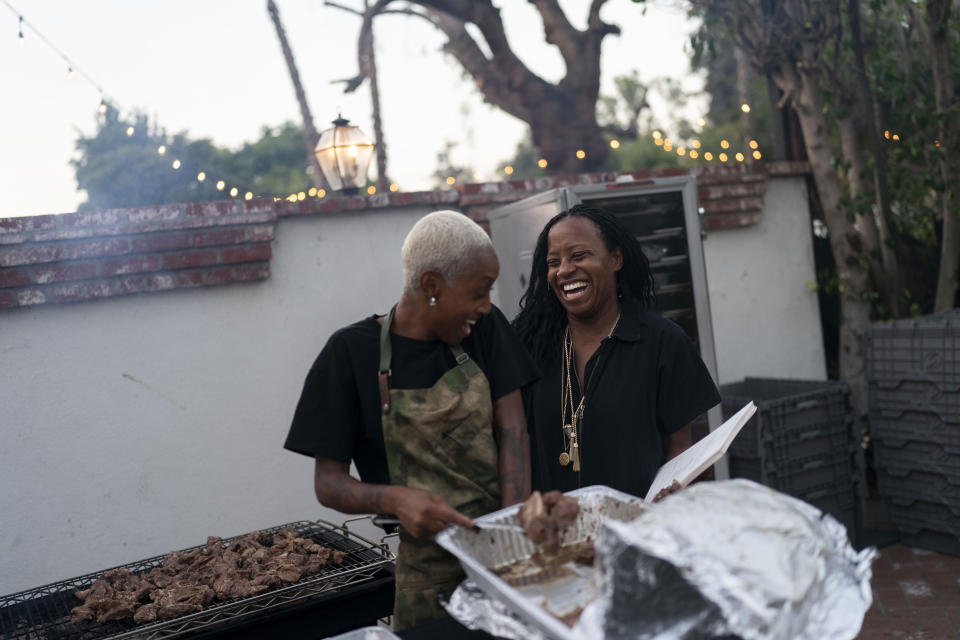 Chef Brittney "Stikxz" Williams, right, and Osayi Endolyn, an inaugural artist-in-residence for the Black Lives Matter Global Network Foundation's Black Joy Creators Fellowship, share a light moment as they get ready for a welcome dinner for the annual Families United 4 Justice Network Conference, hosted by the foundation at its mansion in the Studio City neighborhood of Los Angeles, Thursday, Sept. 28, 2023. (AP Photo/Jae C. Hong)