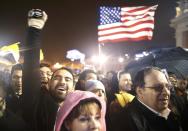 �Faithful cheer near a U.S. flag as white smoke rises from the chimney above the Sistine Chapel in the Vatican, indicating a new pope has been elected at the Vatican March 13, 2013. White smoke rose from the Sistine Chapel and the bells of St. Peter's Basilica rang out on Wednesday, signaling that Roman Catholic cardinals elected a pope to succeed Benedict XVI. REUTERS/Tony Gentile (VATICAN - Tags: RELIGION)