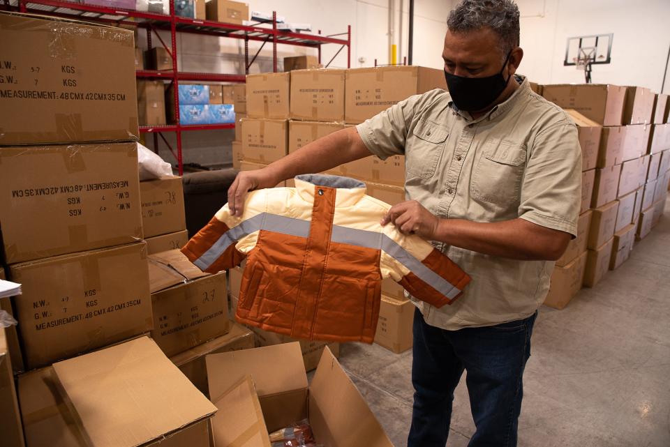 Raul Ramirez on Friday, Dec. 4, 2020, shows one of the thousands of coats that will be distributed to children. Ramirez handles order pickups at the West Side Mattress Firm warehouse. Operation Noel has been an El Paso tradition since 1939 that supplies thousands of needy children with new winter coats.