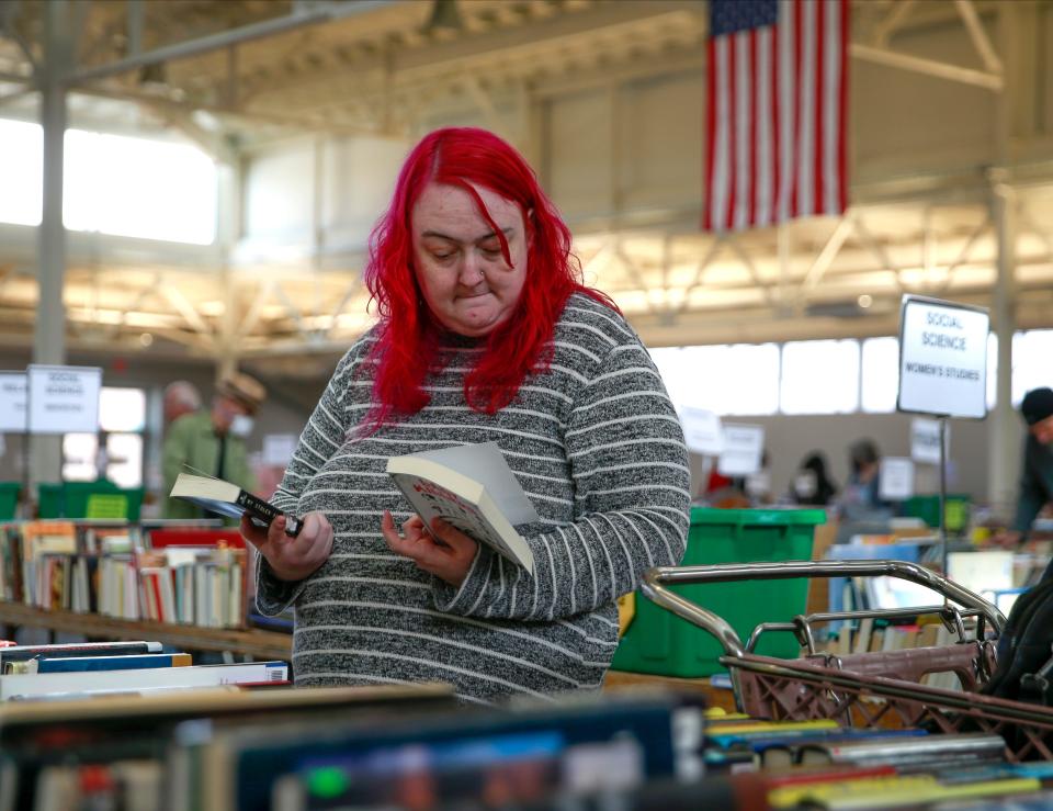 Jessica Bauer, a book lover from Des Moines, looks over the literature section during the annual Planned Parenthood book sale on Thursday, April 21, 2022, at the 4-H building at the Iowa State Fairgrounds in Des Moines.