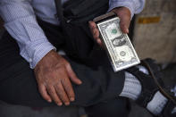 An Iranian street money exchanger holds U.S. banknote in downtown Tehran, Iran, Monday, July 30, 2018. Iran's currency has dropped to a record low ahead of the imposition of renewed American sanctions, with many fearing prolonged economic suffering or possible civil unrest. (AP Photo/Vahid Salemi)