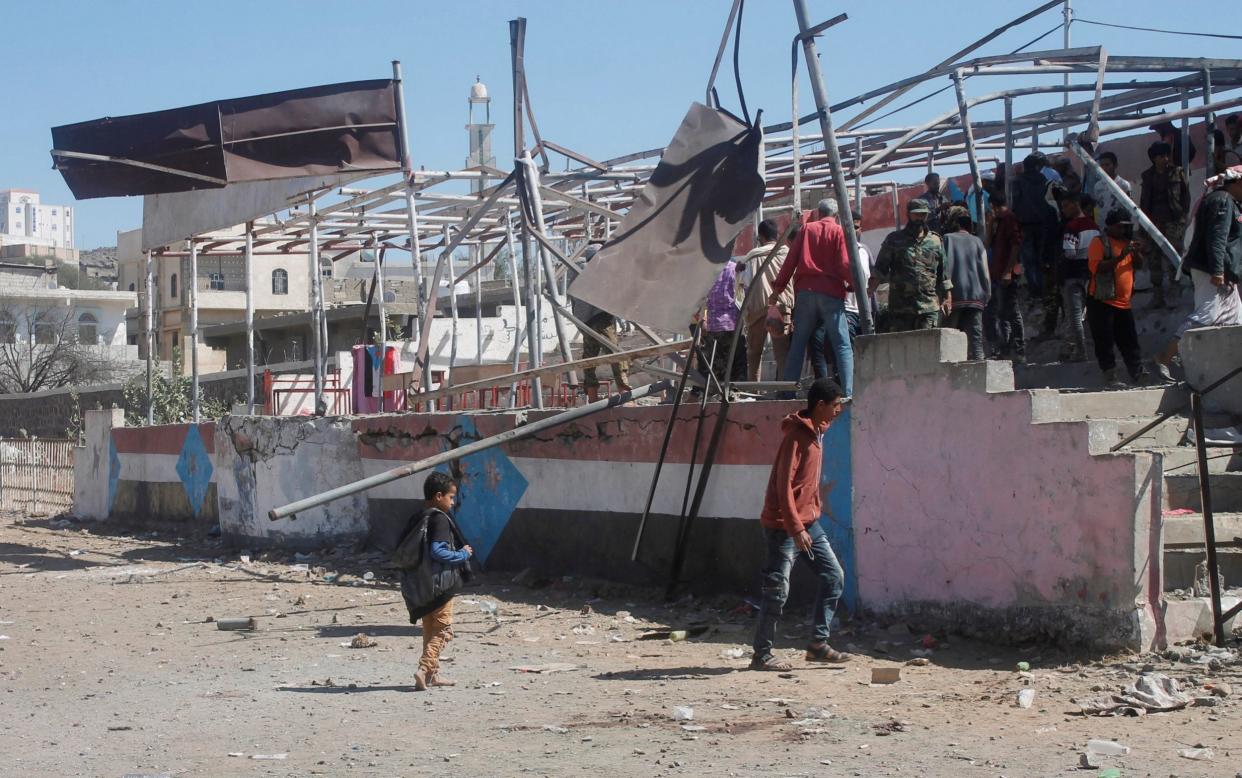 People gather at the scene of a blast which struck a military graduation parade - REUTERS