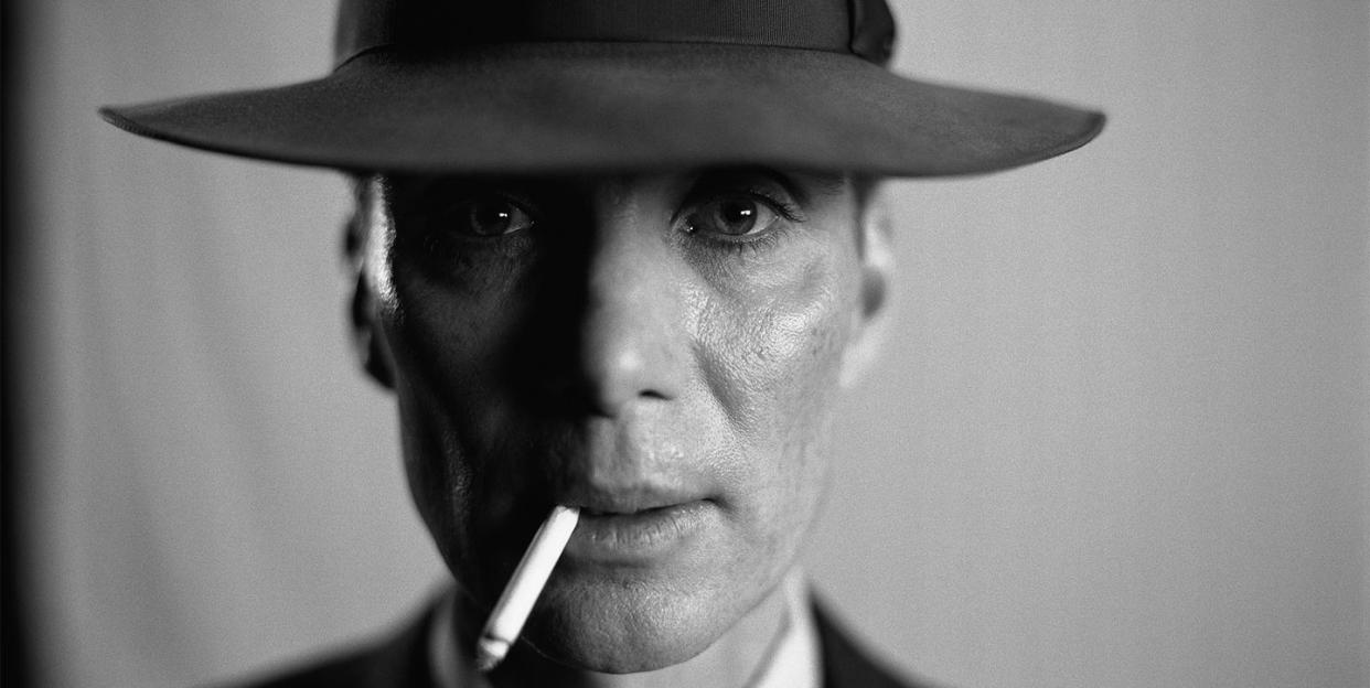 cillian murphy in character as oppenheimer with a hat on smoking in the film